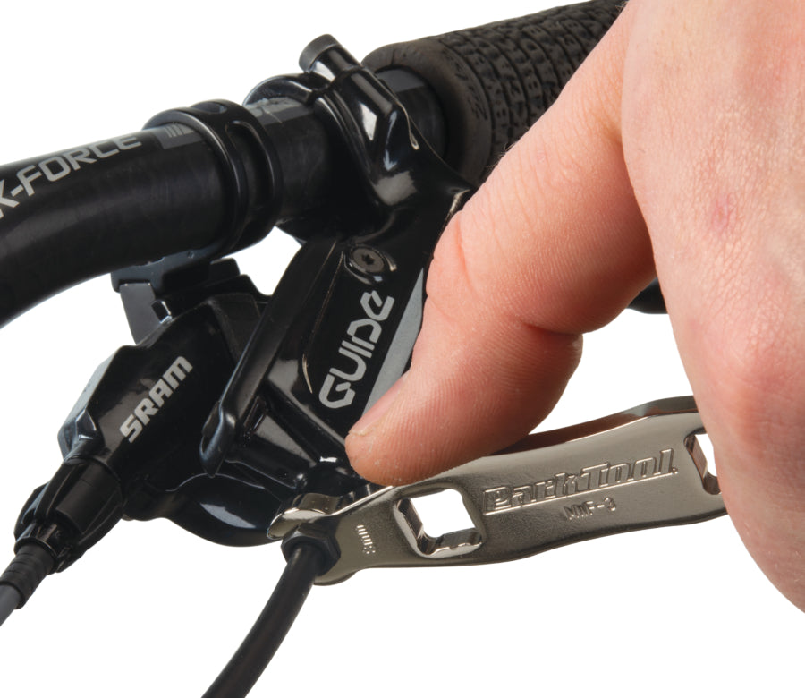 Park Tool MWF-3 serrant un raccord de durite sur levier de frein